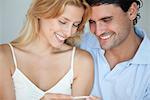 Couple looking at pregnancy test, smiling