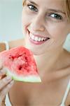 Young woman holding slice of watermelon, portrait