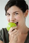 Mid-adult woman biting into apple