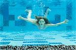 Girl swimming underwater in swimming pool