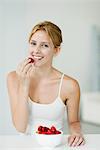 Young woman with bowl of strawberries, portrait