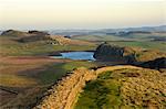 Towards sunset, view east along Hadrians Wall from Windshields Crag to Crag Lough and Hotbank Farm, UNESCO World Heritage Site, Northumberland National Park, Northumbria, England, United Kingdom, Europe