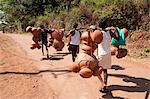 Bonda tribesmen walking to market carrying pots intended for village alcohol production, rural Orissa, India, Asia