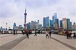 Promeneurs et touristes sur le Bund, la ligne d'horizon futuriste de Pudong sur la rivière Huangpu au-delà, Shanghai, Chine, Asie