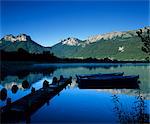 Silhouette of pier and rowing boats, Lake Annecy, Rhone Alpes, France, Europe