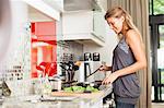 Smiling woman cooking in kitchen