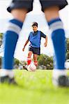 Boys playing soccer on pitch