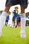 Boys playing soccer on pitch