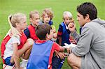 Trainer im Gespräch mit Kinder-Fußball-team