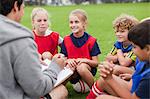Trainer im Gespräch mit Kinder-Fußball-team