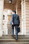 Businessman climbing steps of building