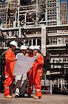 Arbeitnehmer mit Blaupausen an Öl-Raffinerie