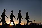 Silhouette of workers at oil refinery