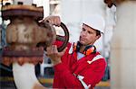 Worker adjusting gauge at chemical plant