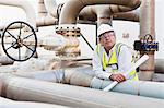 Worker on pipes at chemical plant