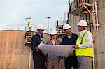 Workers reading blueprints at plant