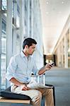 Businessman using cell phone in lobby