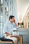 Businessman on cell phone in hallway