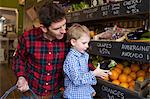 Father and son buying produce in store