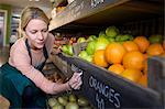 Grocer labeling produce for sale