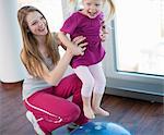 Girls playing with exercise ball in gym