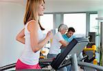 Woman using treadmill in gym