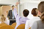 Business people raising hands in seminar