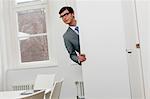 Businessman peering around door