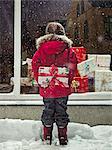 Jeune fille tenant présent dans la neige de Noël