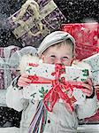 Boy holding Christmas present in snow