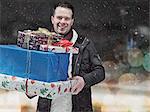 Homme portant des cadeaux de Noël dans la neige