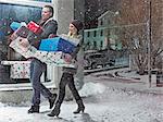 Couple with Christmas gifts in snow