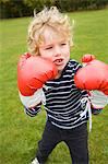 Garçon jouant avec des gants de boxe en plein air