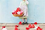 Girl holding basket of paper flowers