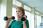 Older woman lifting weights in gym