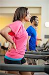 Femme à l'aide de tapis roulant dans une salle de sport