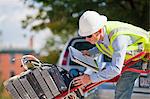 Cable installer with hand truck full of set-top boxes reading work orders