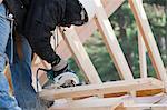 Carpenter using a circular saw making bevel cut