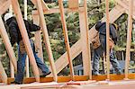 Carpenters moving boards at upper level