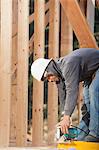 Carpenter cutting beam to length using a circular saw