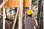 Carpenter using a level on framing