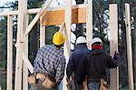 Carpenters preparing to frame exterior wall of a house under construction