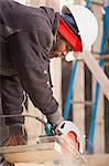 Carpenter using a circular saw for cutting rafter