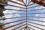 Low angle view of hip roof rafters viewed toward sky