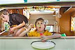 Two boys blowing bubbles out of caravan