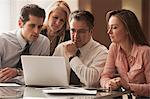 Business colleagues working on laptop on desk