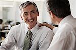 Businessman touching colleagues shoulder in office