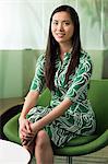 Portrait of young woman in green dress in office