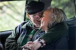 Senior couple embracing in the back of car