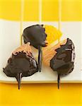 Citrus fruit skewers dipped in melted chocolate